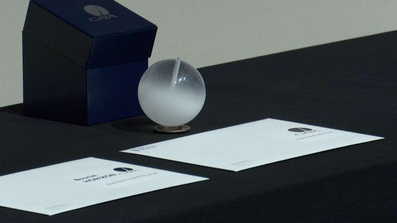 Boîte bleue GAIA avec une sphère de verre dépoli et deux documents papier.