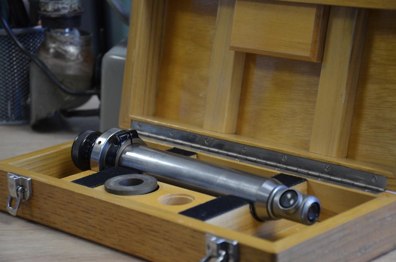 Instrument optique métallique rangé dans son coffret en bois.